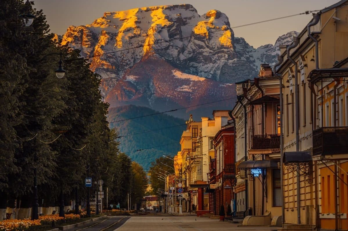 A street in Vladikavkaz, North Ossetia–Alania, with the snow-covered Caucasus mountains glowing at sunrise
